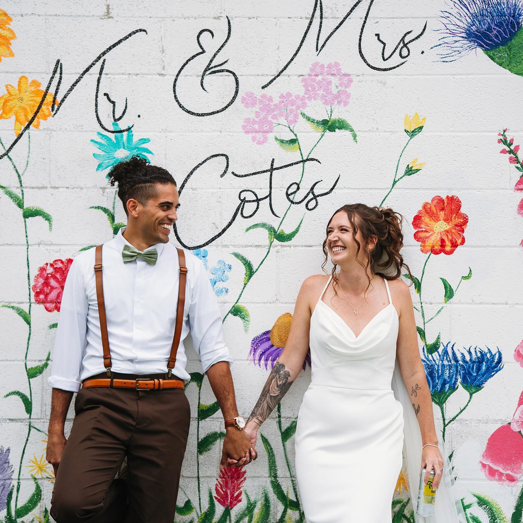 Newlywed couple embracing surrounded by greenery